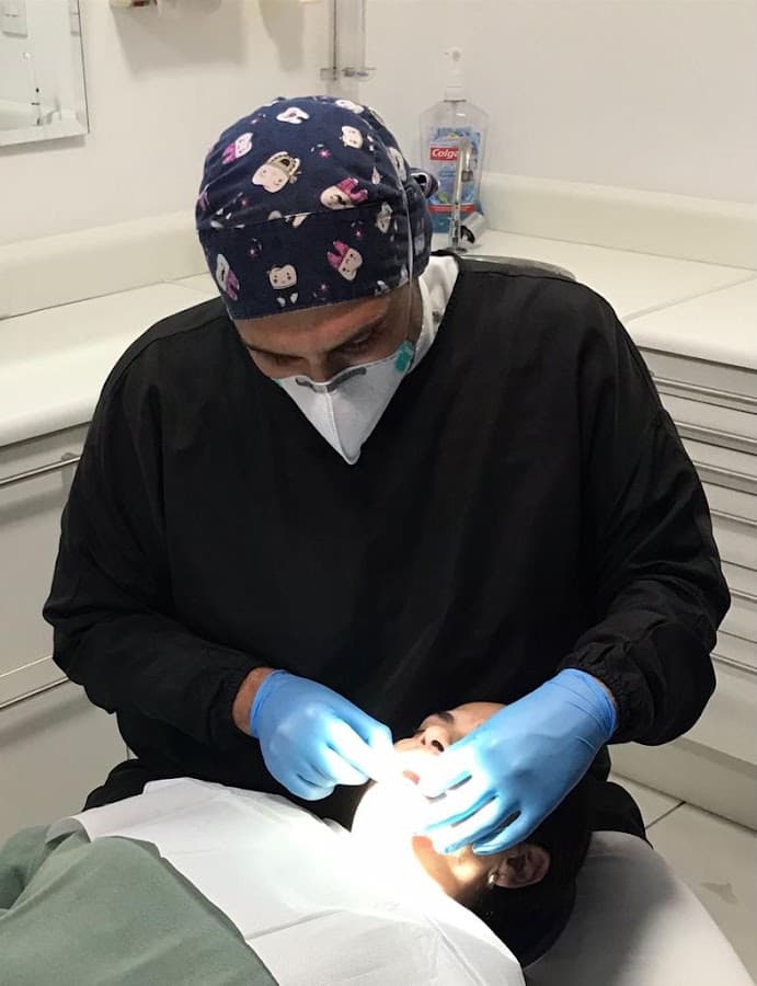 Dentista realizando um atendimento odontológico a um paciente.